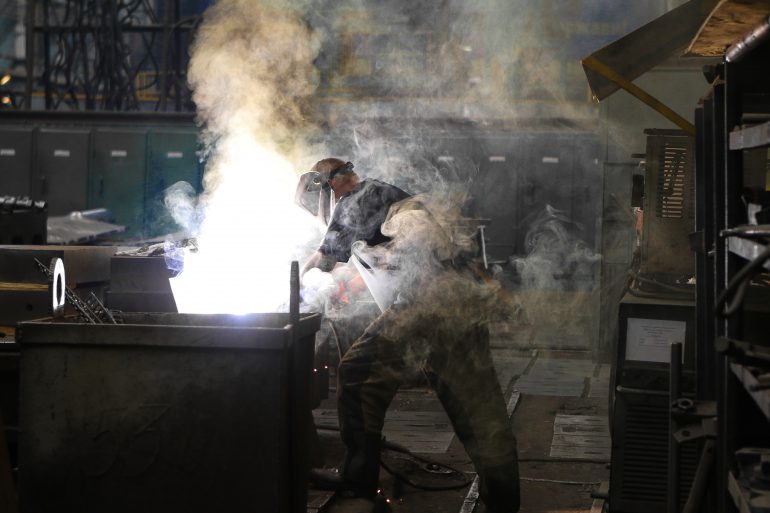 man-wearing-gray-shirt-and-welding-mask-covered-in-welding-2760344